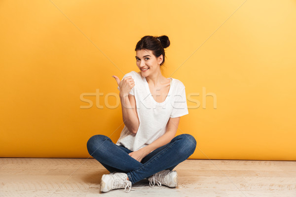 Portrait souriant jeune femme séance jambes croisées étage Photo stock © deandrobot