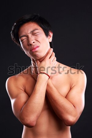 Young male suffering from neck pain on black background Stock photo © deandrobot