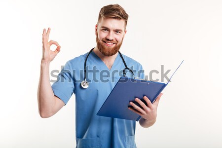 Smiling male doctor giving card over white background Stock photo © deandrobot