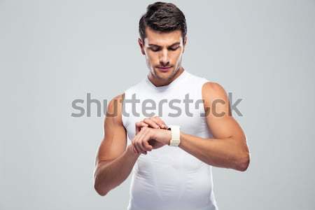 Handsome fitness man using smart watch Stock photo © deandrobot