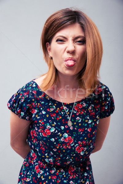 Vrouw tonen tong camera grijs achtergrond Stockfoto © deandrobot