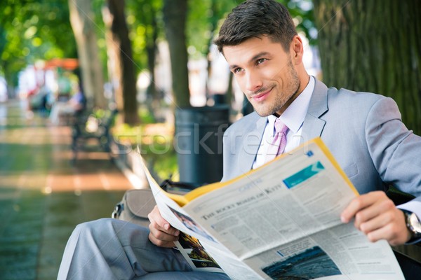 бизнесмен сидят скамейке газета улыбаясь Сток-фото © deandrobot