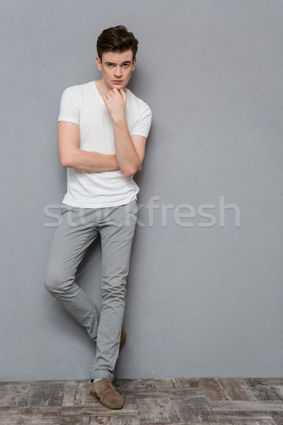 Figyelmes fiatal fickó áll szürke teljes alakos Stock fotó © deandrobot