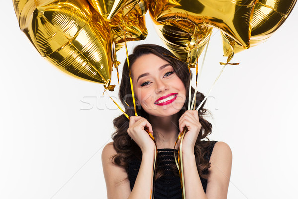 Cheerful happy beautiful woman in retro style holding golden balloons  Stock photo © deandrobot