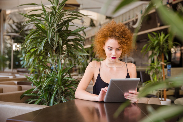 Woman using tablet computer in restaurant Stock photo © deandrobot