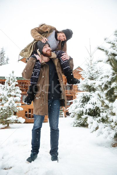 Woman sitting on man shoulders and laughing in winter Stock photo © deandrobot
