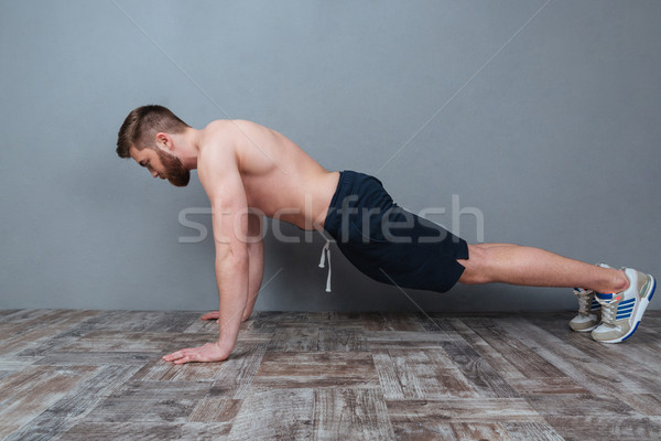 Stock photo: Attractive bearded young man doing push-ups