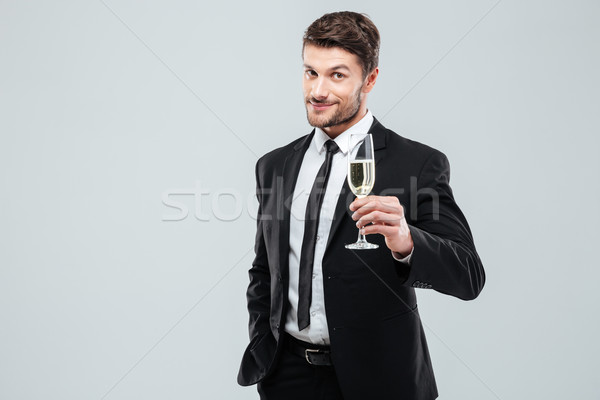 Businessman in suit and tie cheers with glass of champagne Stock photo © deandrobot