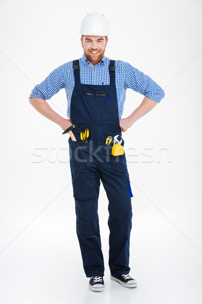 Happy attractive young buider in overall and helmet Stock photo © deandrobot