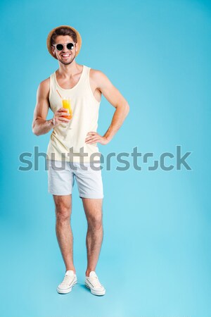 Cheerful young man throwing frisbee disk and showing thumbs up Stock photo © deandrobot