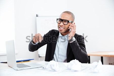 Young businessman talking on mobile phone and looking at camera Stock photo © deandrobot
