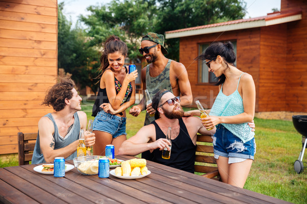 Group of teenage friends drinking beer and eating snacks Stock photo © deandrobot