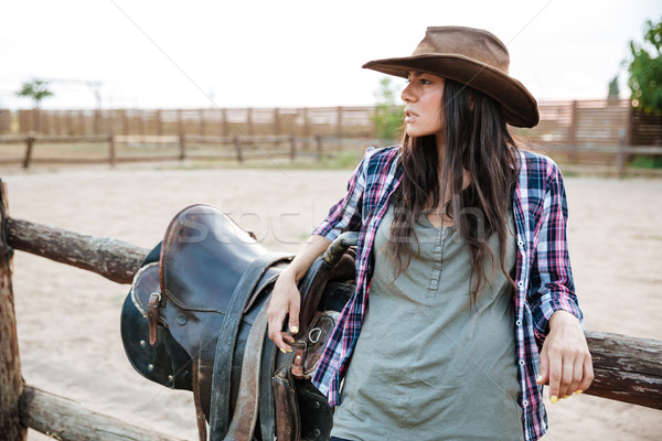 Young cute cowgirl leaning on the ranch fence Stock photo © deandrobot