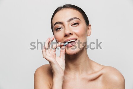 Beauty portrait of a pretty young woman holding pill Stock photo © deandrobot