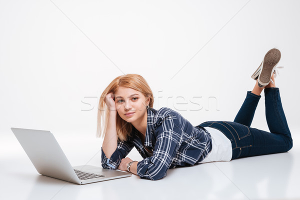 Sevimli genç kadın dizüstü bilgisayar kullanıyorsanız bilgisayar resim yalıtılmış Stok fotoğraf © deandrobot