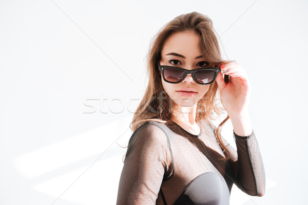 Foto stock: Atraente · senhora · óculos · de · sol · em · pé · estúdio