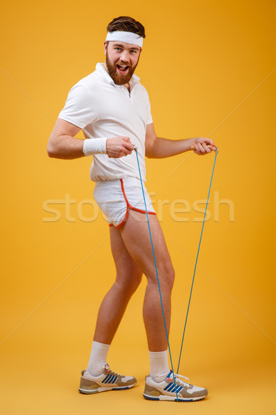 Cheerful young sportsman holding skipping rope Stock photo © deandrobot