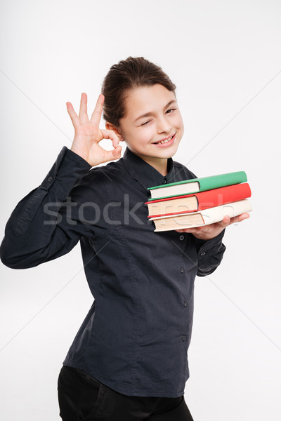Csinos fiatal lány tart könyvek gyártmány oké Stock fotó © deandrobot