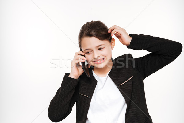 Confused young girl standing and talking by phone Stock photo © deandrobot