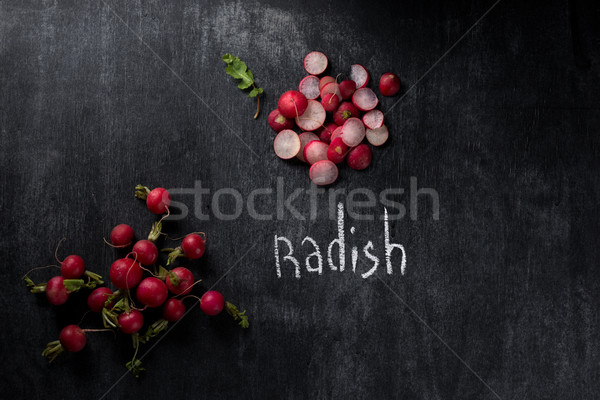 Cut radish over dark chalkboard background Stock photo © deandrobot