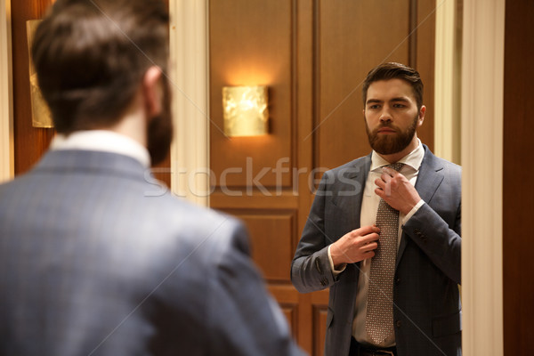 View from back of young man looking at the mirror Stock photo © deandrobot