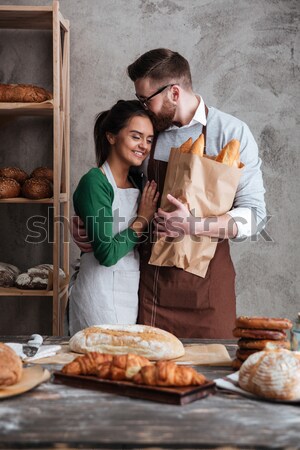 Cheerful loving couple bakers drinking coffee. Looking aside. Stock photo © deandrobot