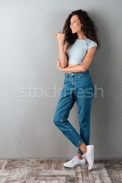 Young woman pointing at copy space isolated Stock photo © deandrobot
