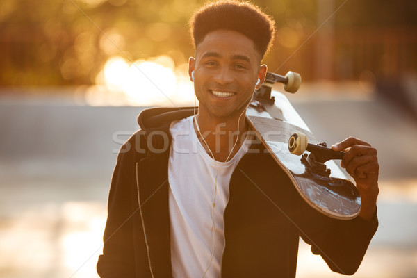 Young skateboarder man holding skateboard Stock photo © deandrobot