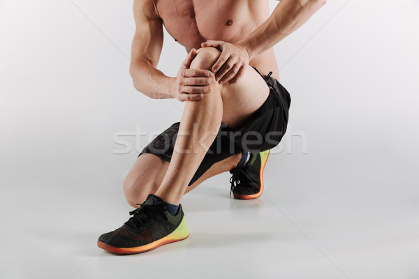 Displeased young sportsman have painful feelings in leg. Stock photo © deandrobot