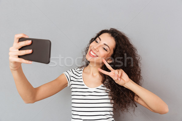 Stock photo: Amazing woman with caucasian appearance making selfie on her sma