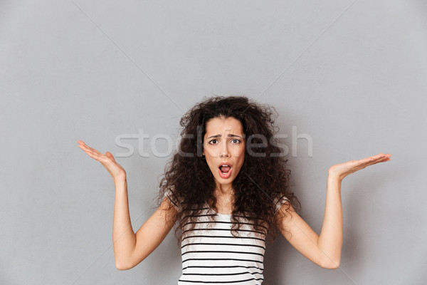 Pretty adult girl wearing striped t-shirt throwing up hands mean Stock photo © deandrobot