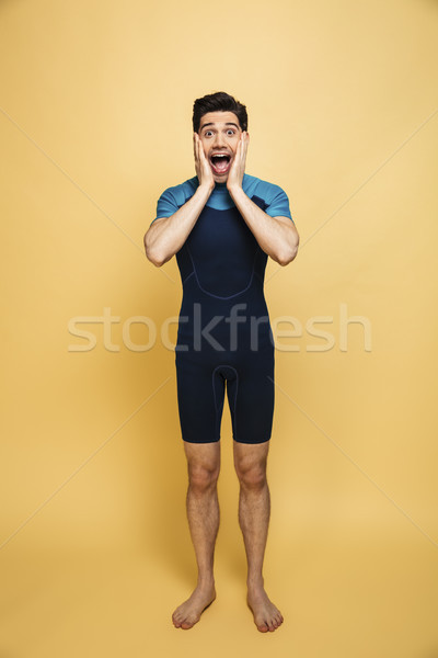 Geschokt jonge man zwempak foto geïsoleerd Geel Stockfoto © deandrobot