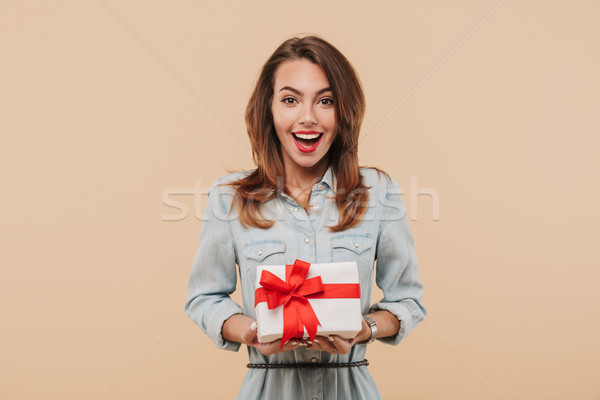 Portrait of an excited young girl holding present box Stock photo © deandrobot