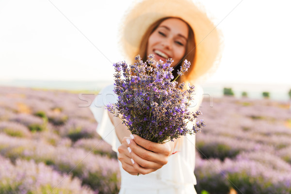 Happy young girl in straw hat holding lavender Stock photo © deandrobot