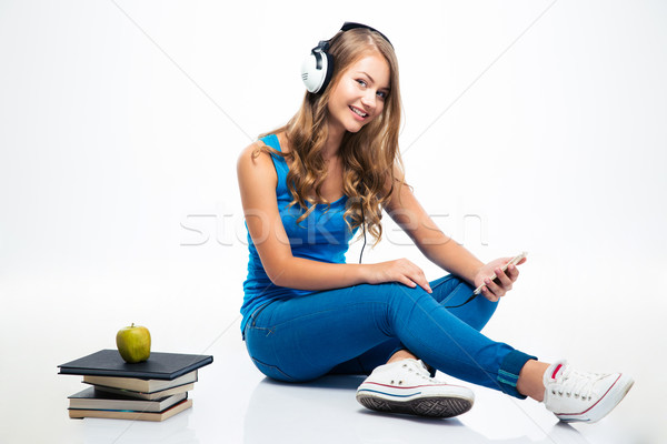 Woman listening music in headphones on smartphone Stock photo © deandrobot