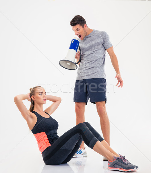 Trainer screaming through loudspeaker on a  woman to doing exercises  Stock photo © deandrobot
