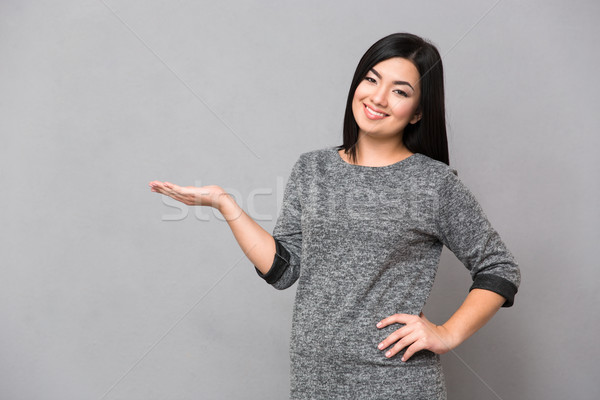 Asian girl holding copyspace on the palm Stock photo © deandrobot