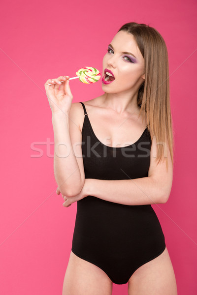 Elbűvölő lány eszik nyalóka vonzó gyönyörű lány Stock fotó © deandrobot