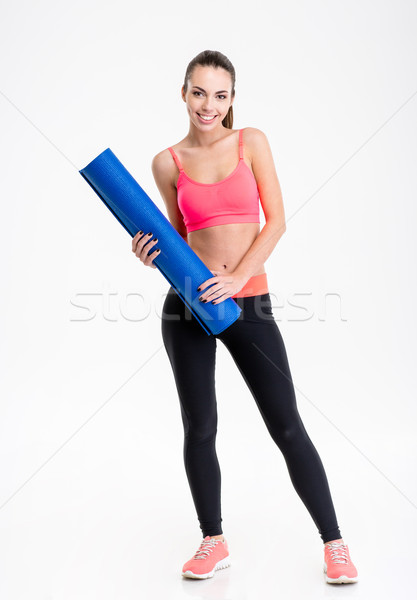 Hermosa feliz mujer de la aptitud pie estera de yoga Foto stock © deandrobot