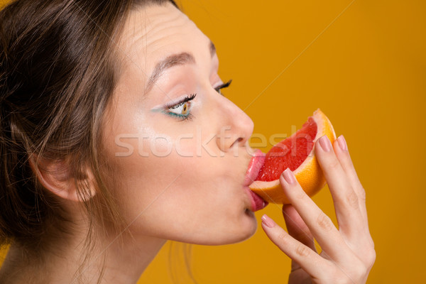 Profile of cute lovely young woman eating fresh grapefruit Stock photo © deandrobot