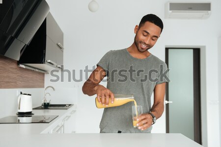 Feliz homem bonito em pé cozinhar cozinha azul Foto stock © deandrobot