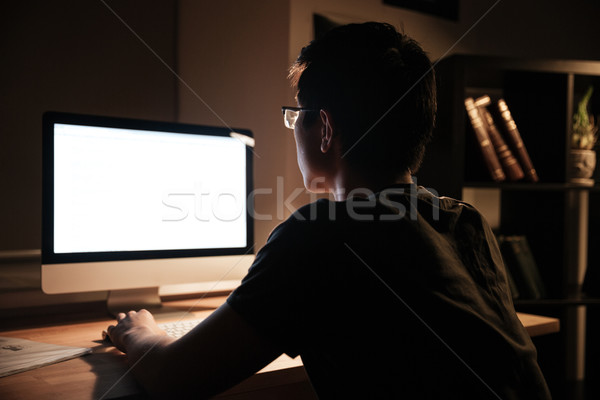 Serious man working with blank screen computer at nighttime Stock photo © deandrobot