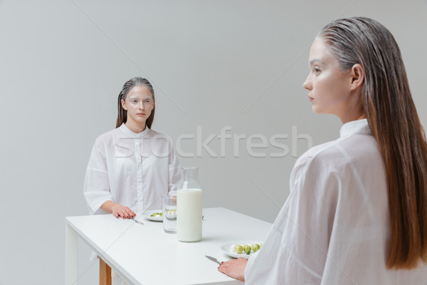 Two women sitting at the table with food Stock photo © deandrobot