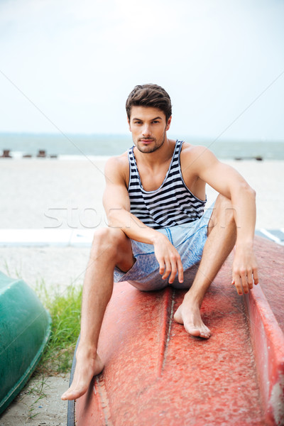 élégant jeune homme séance mer regarder [[stock_photo]] © deandrobot