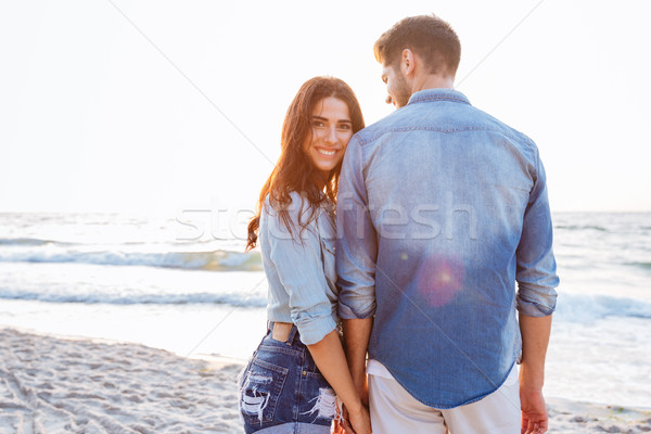 Beautiful young woman holding her boyfriend hand who standing backwards Stock photo © deandrobot