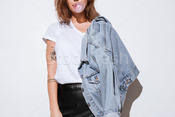 Cropped photo of young lady blowing bubble with chewing gum. Stock photo © deandrobot