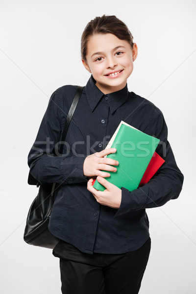 Happy young girl wearing backpack holding books Stock photo © deandrobot