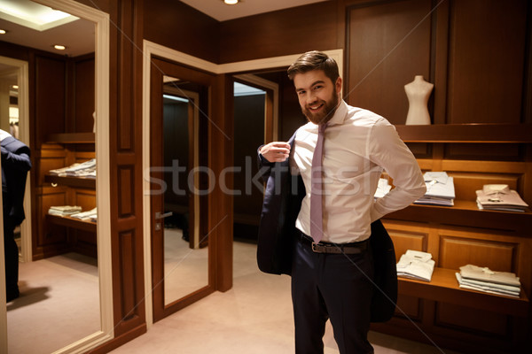 Happy Man putting on his jacket Stock photo © deandrobot