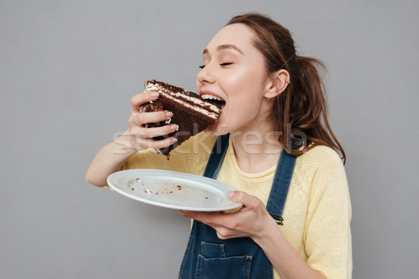 Hungrig jungen essen Schokoladenkuchen Stock foto © deandrobot