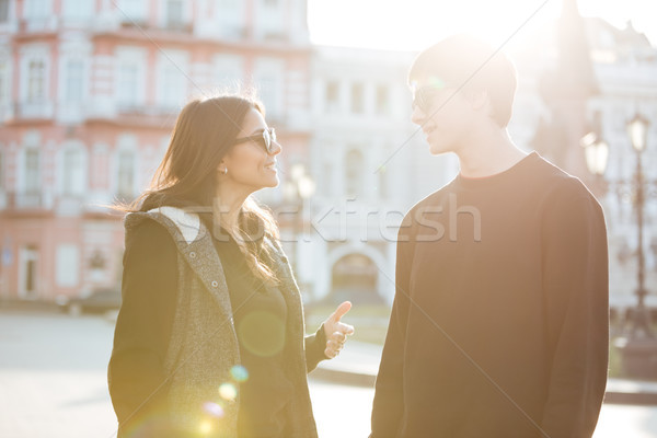 Happy young lady walking outdoors with her brother. Stock photo © deandrobot